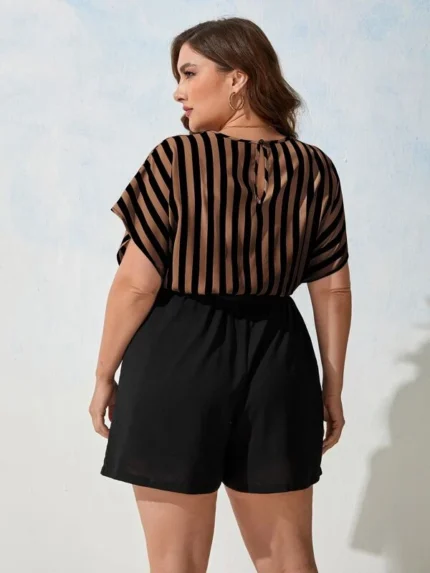 Macaquinho Plus Size Listrado Pâmela, com manga morcego, decote V, cinto e estampa listrada. Versátil, leve e estiloso para qualquer ocasião.