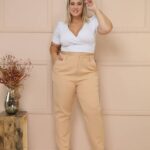 Calça Plus Size Tânia em alfaiataria, cor bege, perna reta, cintura natural, com bolsos e zíper. Prática, elegante e ideal para diversas ocasiões.