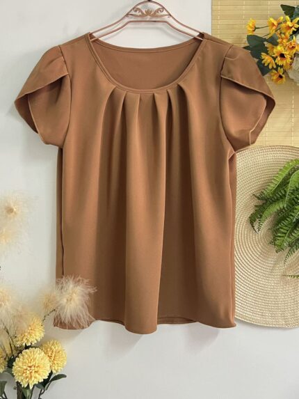 Blusa Plus Size Laís em rosê, com mangas curtas de pétala, gola redonda, bainha flared e detalhes dobrados. Confortável e elegante para o dia a dia.