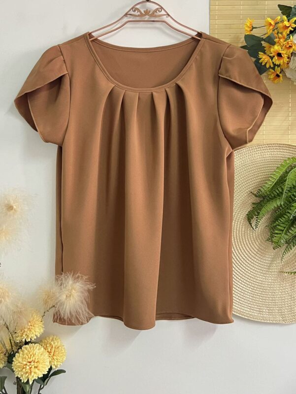 Blusa Plus Size Laís em rosê, com mangas curtas de pétala, gola redonda, bainha flared e detalhes dobrados. Confortável e elegante para o dia a dia.