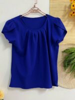 Blusa Plus Size Laís em rosê, com mangas curtas de pétala, gola redonda, bainha flared e detalhes dobrados. Confortável e elegante para o dia a dia.