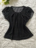 Blusa Plus Size Fernanda com estampa de bolinhas poá, fundo preto, mangas pétala, gola redonda. Confortável, clássica e versátil.