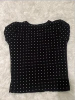 Blusa Plus Size Fernanda com estampa de bolinhas poá, fundo preto, mangas pétala, gola redonda. Confortável, clássica e versátil.