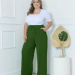 Calça Pantalona Plus Size Amora em verde militar, design de perna larga, cintura natural, bolsos funcionais. Versátil e confortável.
