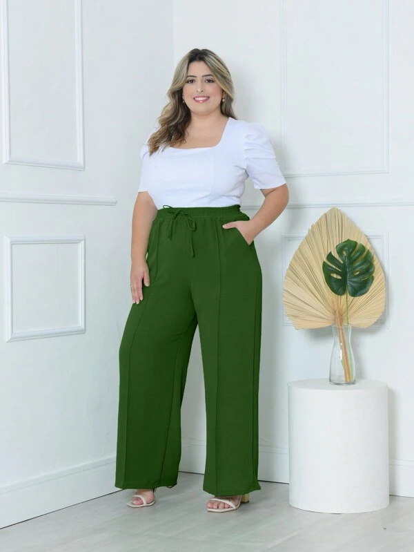 Calça Pantalona Plus Size Amora em verde militar, design de perna larga, cintura natural, bolsos funcionais. Versátil e confortável.
