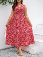 Vestido Plus Size Carla, boho, com estampa de plantas e flores em fundo preto, cintura alta, decote V, detalhes cruzados e franzidos.