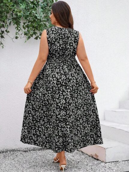 Vestido Plus Size Carla, boho, com estampa de plantas e flores em fundo preto, cintura alta, decote V, detalhes cruzados e franzidos.