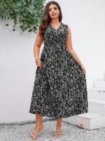 Vestido Plus Size Carla, boho, com estampa de plantas e flores em fundo preto, cintura alta, decote V, detalhes cruzados e franzidos.