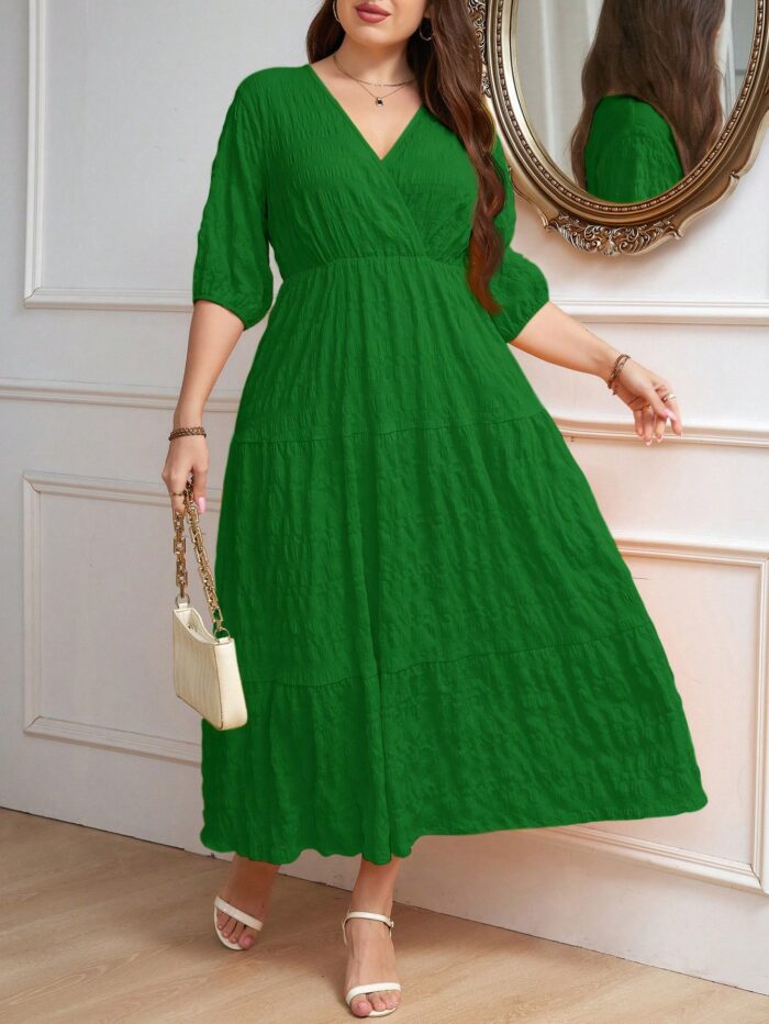 Vestido Plus Size Amanda em rosa chiclete, design em A, cintura alta, mangas bishop, decote V, babados esvoaçantes e detalhes cruzados.