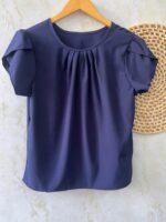 Blusa Plus Size Laís em rosê, com mangas curtas de pétala, gola redonda, bainha flared e detalhes dobrados. Confortável e elegante para o dia a dia.