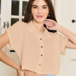 Camisa feminina cropped cor damasco, com manga morcego e detalhes de botões. Tecido leve, perfeito para dias quentes e visuais casuais.