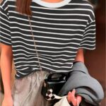 Blusa feminina listrada verde água, manga regular e cintura contrastada. Ideal para dias casuais, com tecido leve e confortável.