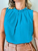 Blusa feminina regata amarela, sem mangas, com gola redonda e detalhes de botão. Leve e elegante, ideal para um visual casual e sofisticado.