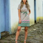 Vestido casual Caroline com estampa geométrica, cinto e gola redonda. Mangas curtas, caimento leve e bainha reta. Confortável e ideal para diversas ocasiões.