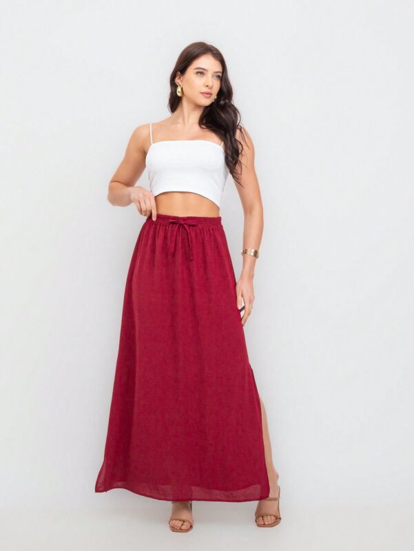Saia Fátima com fenda lateral, babado e cintura alta. Feita de viscose, disponível em estampas tropicais ou sem estampa, ideal para looks casuais.
