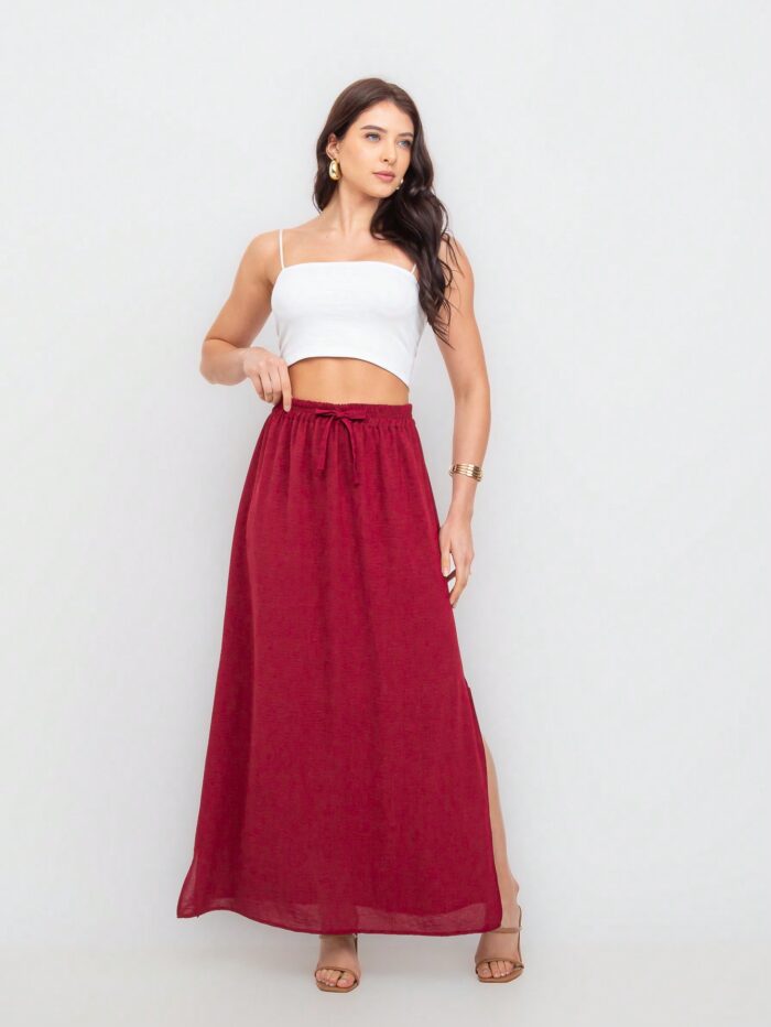 Saia Fátima com fenda lateral, babado e cintura alta. Feita de viscose, disponível em estampas tropicais ou sem estampa, ideal para looks casuais.