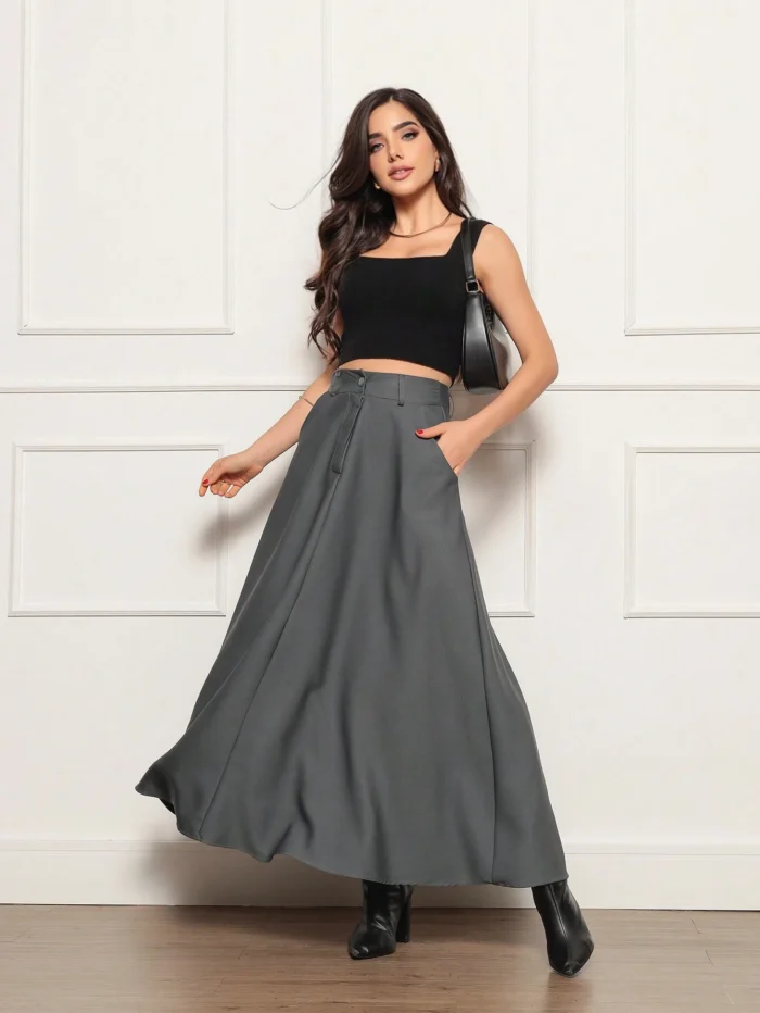 Saia longa Valentina, sem estampa, com cinto e detalhes de corrente. Feita de poliéster, oferece caimento solto e cintura alta, perfeita para looks sofisticados.