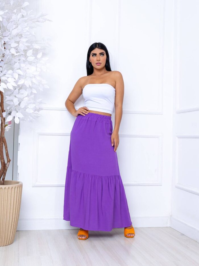Saia longa Joana em viscolinho com cintura alta e babados, ideal para looks boho. Sem estampa, leve e fluida, perfeita para dias quentes e visuais elegantes.