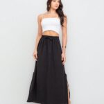 Saia Fátima com fenda lateral, babado e cintura alta. Feita de viscose, disponível em estampas tropicais ou sem estampa, ideal para looks casuais.