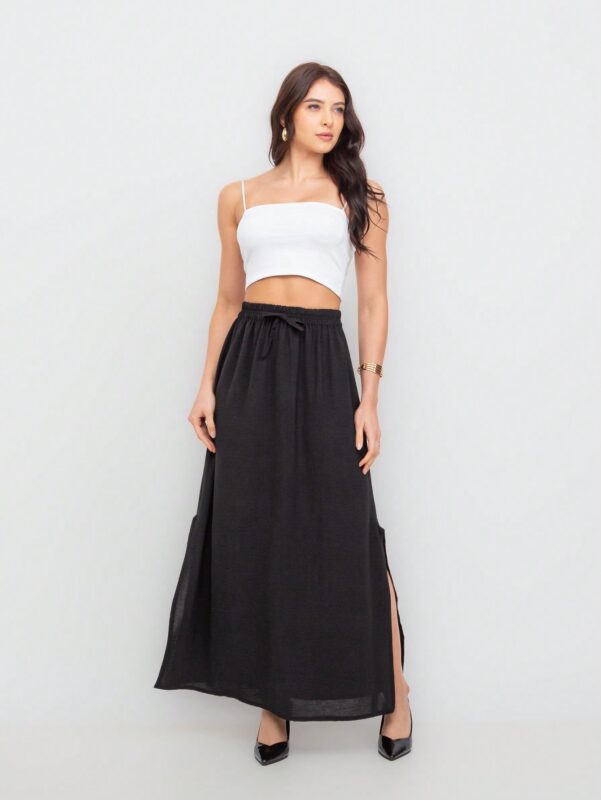 Saia Fátima com fenda lateral, babado e cintura alta. Feita de viscose, disponível em estampas tropicais ou sem estampa, ideal para looks casuais.