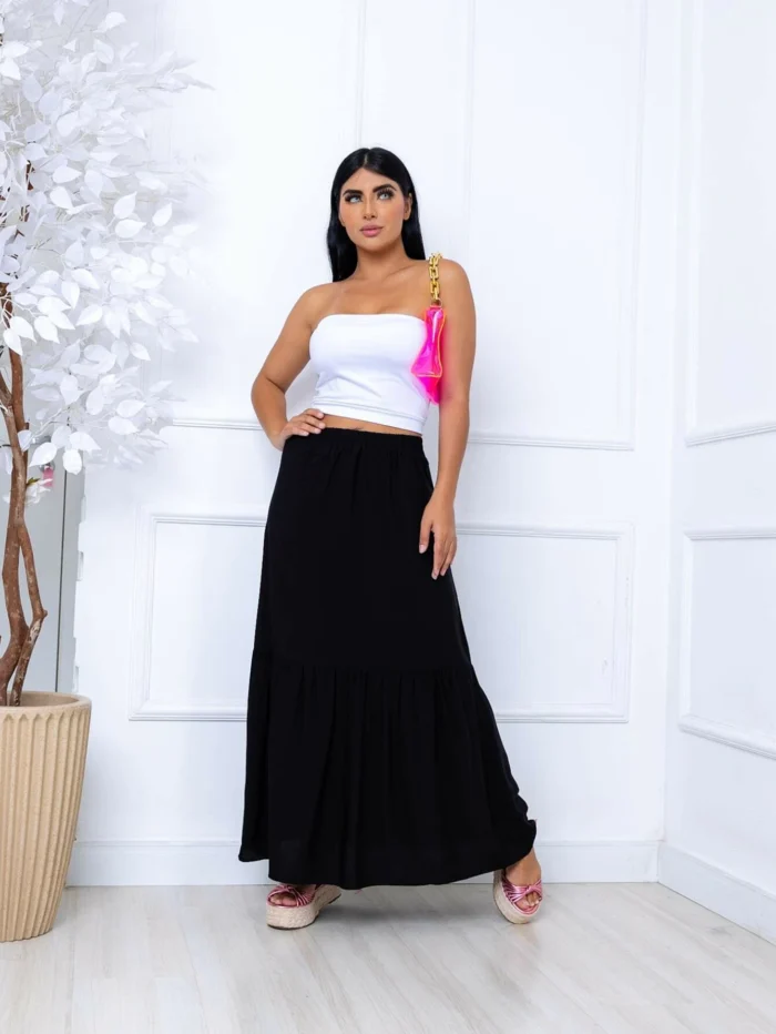 Saia longa Joana em viscolinho com cintura alta e babados, ideal para looks boho. Sem estampa, leve e fluida, perfeita para dias quentes e visuais elegantes.