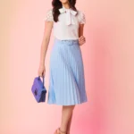 Saia midi Nara com cinto de ilhó e plissados, confeccionada em Helanca Light. Ideal para um visual casual e sofisticado, com cintura alta e sem estampa.