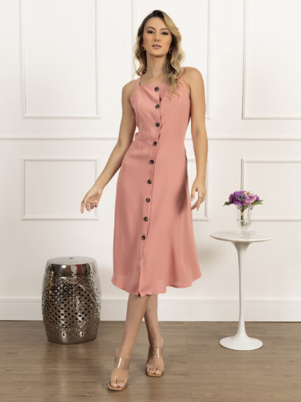 Vestido midi Janaina sem mangas, com cintura alta e design suspensório. Feito de poliéster, oferece caimento fluido e confortável. Versátil para diversas ocasiões.