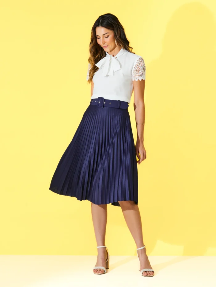 Saia midi Nara com cinto de ilhó e plissados, confeccionada em Helanca Light. Ideal para um visual casual e sofisticado, com cintura alta e sem estampa.