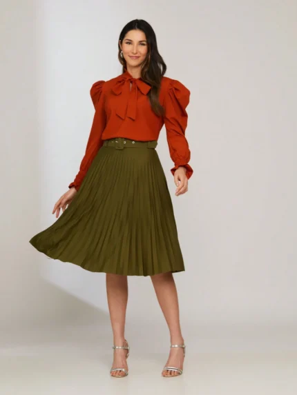 Saia midi Nara com cinto de ilhó e plissados, confeccionada em Helanca Light. Ideal para um visual casual e sofisticado, com cintura alta e sem estampa.