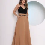 Saia longa Valentina, sem estampa, com cinto e detalhes de corrente. Feita de poliéster, oferece caimento solto e cintura alta, perfeita para looks sofisticados.